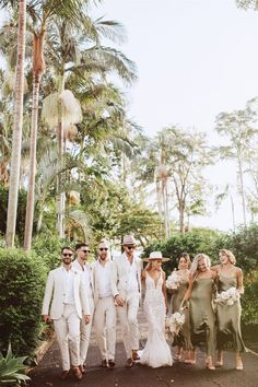 a group of people standing next to each other in front of some trees and bushes