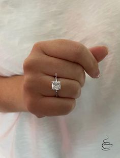 a woman's hand with a diamond ring on it