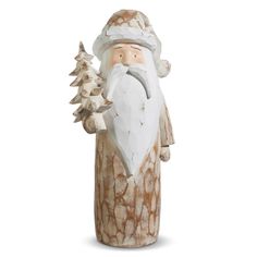 a statue of santa claus holding a pine tree in his right hand and wearing a white hat