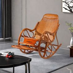 a wooden rocking chair sitting on top of a living room floor next to a window