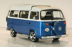 a blue and white vw bus parked in a room