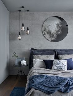 a large bed sitting under a round mirror next to a wall mounted light above it