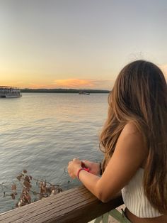 a woman is looking out over the water