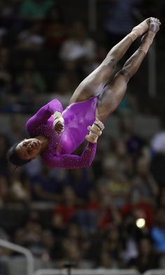 a woman is performing on the balance beam