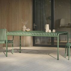 a green table and two chairs in front of a sliding glass door