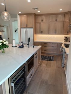 a kitchen with white counter tops and wooden cabinets