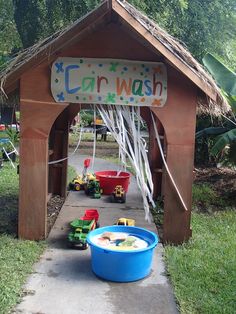 a child's toy car wash station with toys in the bucket on the sidewalk