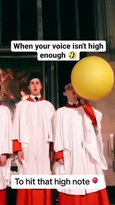 three men wearing white robes and red pants are standing in front of a yellow balloon