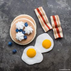 some food is laying out on a table with bacon and eggs in the shape of pancakes