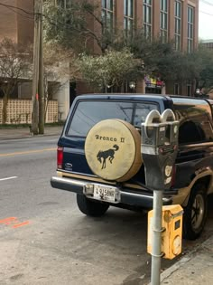 a truck parked next to a parking meter on the side of the road with a barrel painted on it