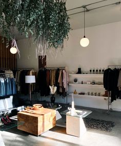 a clothing store with clothes hanging from the ceiling and other items on display in front of them