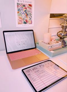 an open laptop computer sitting on top of a desk next to a clipboard with writing