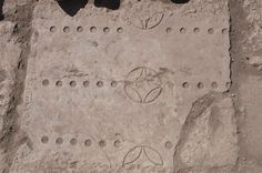 a cement wall with holes and circles on it