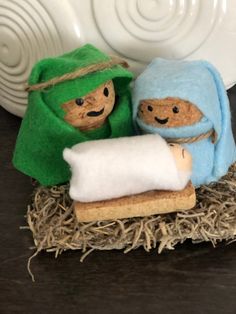 two small stuffed animals sitting on top of a pile of hay