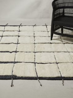 a black chair sitting on top of a white rug