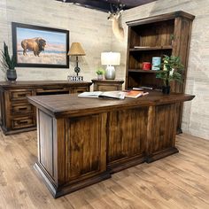 a large wooden desk sitting inside of a room next to a book shelf and lamp