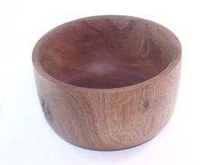 a wooden bowl sitting on top of a white table