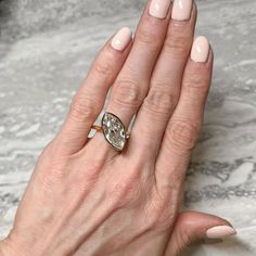 a woman's hand with a ring on it and a diamond in the middle