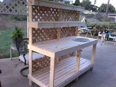 an outdoor kitchen made out of pallets and wooden slats, with a sink on top