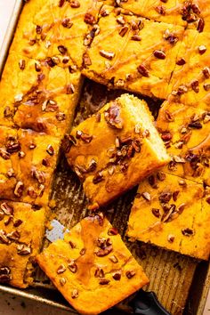 pumpkin bread with pecans on top in a baking pan, ready to be eaten