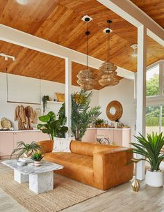 a living room filled with lots of furniture and plants