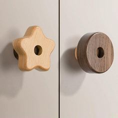 two wooden door knobs on the side of a white cabinet with a star design