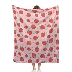 a woman is holding up a pink blanket with strawberries on it and the back of her head