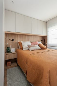 the bed is made up with many pillows and blankets on it, along with two nightstands