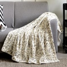 a couch with a blanket on top of it next to a black and white rug