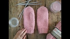 pink mittens and other crafting supplies laid out on a wooden table