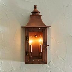 an old fashioned wall light with two lights on it's side and one light in the middle