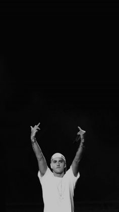 a man standing on top of a tennis court holding his hands up in the air