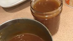 two jars filled with brown liquid sitting on top of a counter