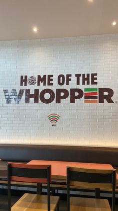 the interior of a restaurant with a large sign on the wall that says, home of the whopper