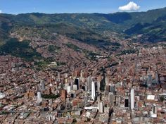 an aerial view of a city with mountains in the background