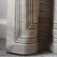 a close up view of the side of a curtain with vertical striped fabric on it