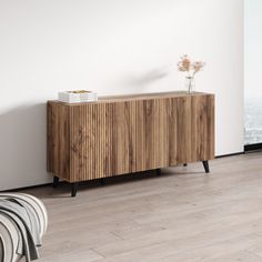 a wooden cabinet in the corner of a room with white walls and wood flooring