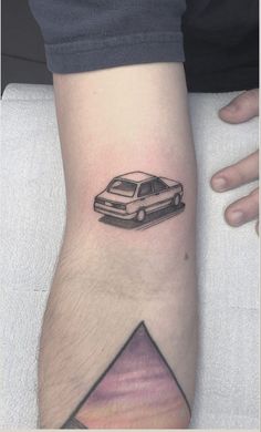 a small car tattoo on the left arm and leg, with a triangle around it