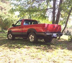 a red pick up truck parked in the grass