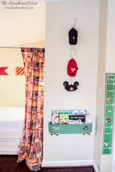 a room with a bed, window and mickey mouse head hanging on the wall next to it