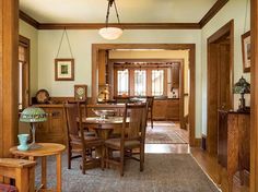 a dining room and kitchen area with wood paneling on the walls, hardwood floors, and wooden furniture