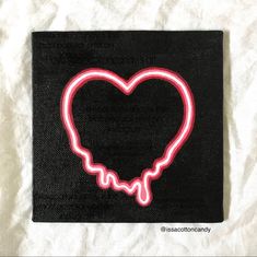 a heart - shaped neon sign on a black cloth with a white background is shown