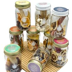 several jars filled with different types of food on top of a wooden tray next to each other