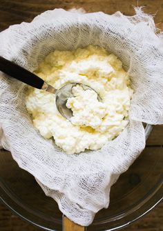 mashed potatoes in a glass bowl with a wooden spoon