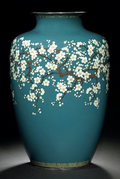 a blue vase with white flowers painted on it