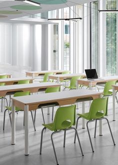 an empty classroom with green and white desks