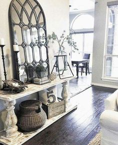 a living room filled with furniture and a large mirror on top of a wooden floor