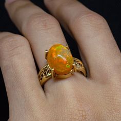 ✨ Experience the Radiance of Fire Opal ✨ Indulge in the luxurious charm of our Fire Opal Gold Ring, a masterpiece of filigree artistry crafted with meticulous attention to detail. This exquisite piece, featuring a Minimalist Opal Ring design, is perfect for those with refined tastes seeking Unique Opal Design, handcrafted jewelry. 🔹 Ring Features: Material: Solid gold with 14k purity, marked by JR14kMX for authenticity. Design: Comfort fit band with an elegant filigree pattern that enhances the unique characteristics of the Mexican Opal Jewelry. Craftsmanship: Handmade using traditional jewelry techniques such as casting, forging, and filigree, qualifying it as Artistic Jewelry. 🔸 Gemstone Insight: Type: Genuine Mexican fire opal, known for its vibrant color and captivating play of light Opal Ring Design For Women, Mexican Fire Opal Jewelry, Minimalist Opal Ring, Scorpio Jewelry, Custom Gold Rings, Opal Gold Ring, Fire Opal Jewelry, Gold Ring For Women, Mexican Opal