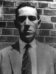 an old photo of a man wearing a suit and tie in front of a brick wall