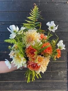 a person holding a bouquet of flowers in their hand